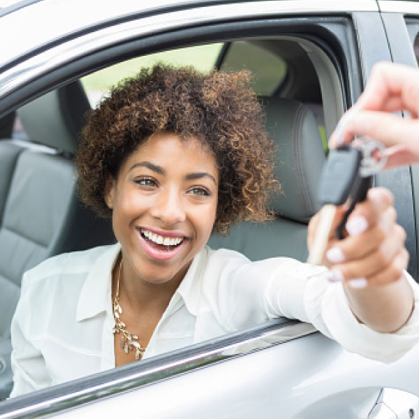 Woman being handed keys to a car