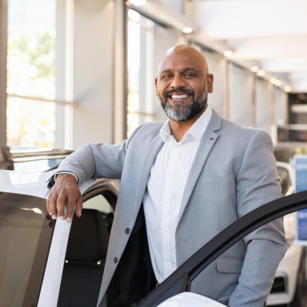 Man standing next to new car