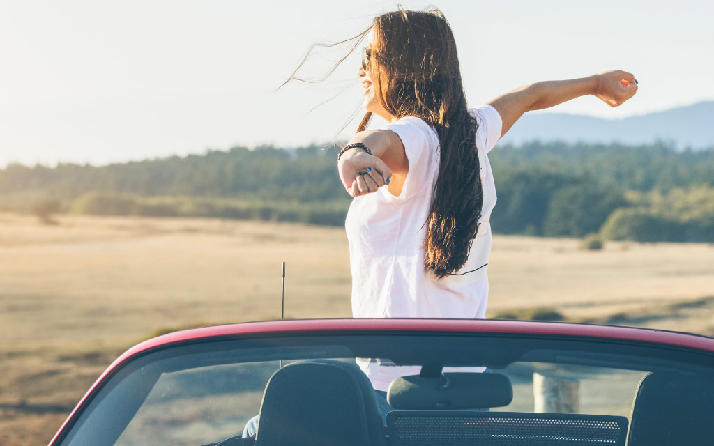 Woman smiling while sitting in convertible