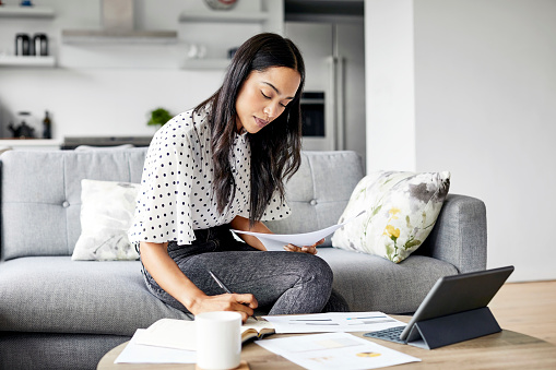 Woman analyzing her bills in her living room.