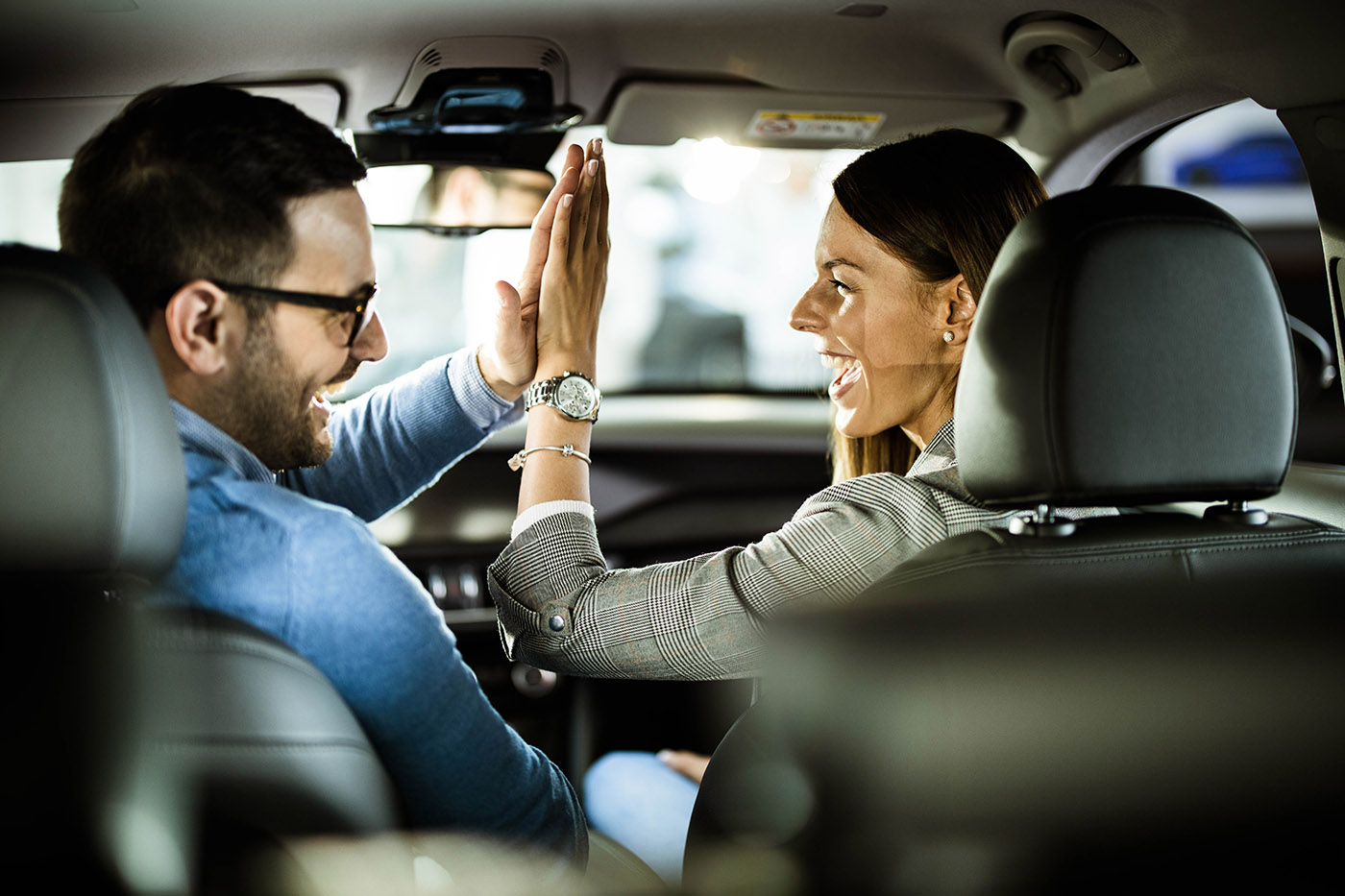 Couple high-fiving in the car