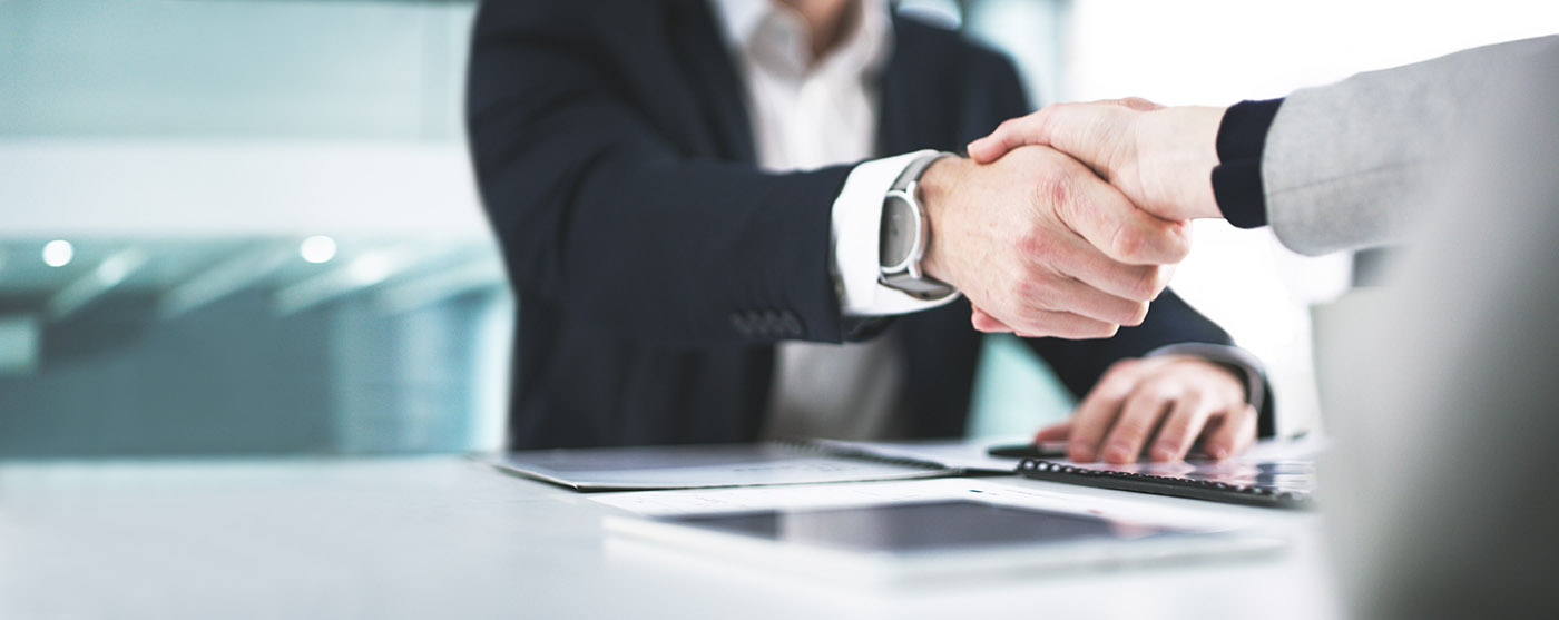 Closeup shot of two businesspeople shaking hands in an office